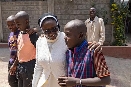 Schwester Modesther von der Caritas Nairobi mit Jugendlichen. Foto: Norbert Staudt/pde 